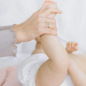 pexels-photo-5889980-5889980 Close-up of a baby's legs being gently held by a mother's hands, symbolizing tender care.